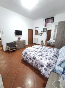 a bedroom with a bed and a couch and a tv at Appartamento c&y via S Lorenzo in Novara