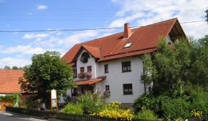 a white house with an orange roof at Gästehaus & Ferienhof Hüfner in Speicherz