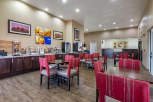 a restaurant with red chairs and tables and a counter at Comfort Inn & Suites in Deming