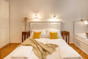 a bedroom with a large white bed with two yellow pillows at Templová 7 - Old Town Apartments in Prague