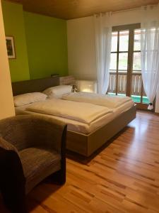 1 Schlafzimmer mit 2 Betten und einem Stuhl in der Unterkunft Gästehaus & Ferienhof Hüfner in Speicherz