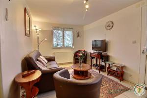 a living room with two couches and a television at la lande romaine in Plourivo
