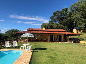 a house with a yard with a swimming pool at Chácara Verzani in Socorro