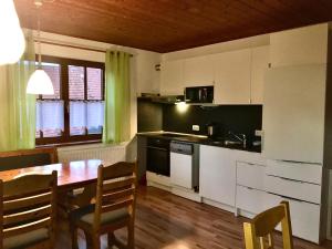 eine Küche mit Holztisch und ein Esszimmer in der Unterkunft Gästehaus & Ferienhof Hüfner in Speicherz