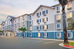 a large apartment building with blue and white at WoodSpring Suites Pharr in Pharr