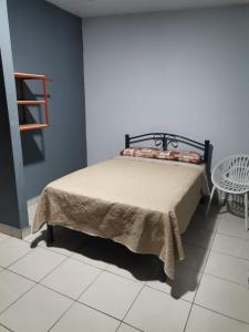 Bett in einem Zimmer mit einem Tisch und einem Stuhl in der Unterkunft Chambres en Ville in David