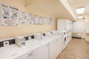 a laundry room with white appliances and signs on the wall at WoodSpring Suites Brownsville in Brownsville