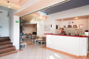 a child standing at a counter in a hospital lobby at Minoa Hotel in Malia