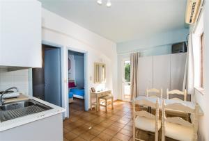 una cucina e una sala da pranzo con tavolo e sedie di Minoa Hotel a Mália
