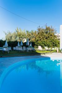 a swimming pool with lounge chairs and a swimming pool at Minoa Hotel in Malia