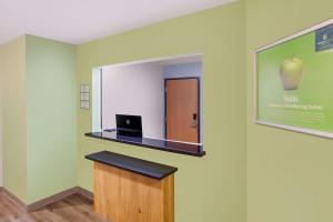 a room with a mirror and a laptop on a wall at WoodSpring Suites Harlingen in Harlingen