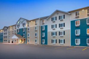 a row of apartment buildings in a parking lot at WoodSpring Suites Harlingen in Harlingen