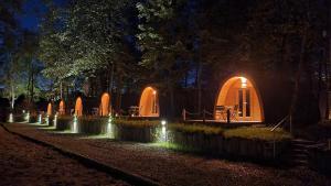 29 Premium Camping Pod في Silberstedt: صف من الألحفة في الليل مع الأضواء