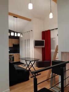een woonkamer met een zwarte bank en een tafel bij Appartement de charme DISNEYLAND PARIS - Nidouest in Chanteloup-en-Brie