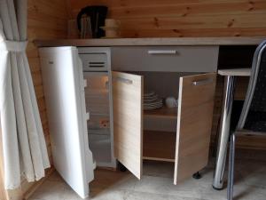 Silberstedt的住宿－26 Premium Camping Pod，厨房配有柜台和开放式冰箱。