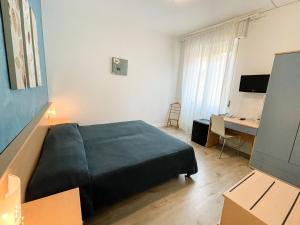 Schlafzimmer mit einem Bett und einem Schreibtisch mit einem Computer in der Unterkunft Hotel Alpino in Malcesine