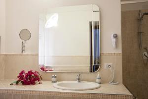 um lavatório de casa de banho com um espelho grande e flores em B&B La Terrazza em Cetraro
