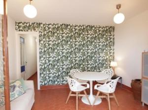 een eetkamer met een tafel en witte stoelen bij Salou 2 · House2 garden in front of the beach - Ferrari Land in Salou