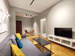 a living room with a couch and a flat screen tv at Veno Apartments Goudi in Athens