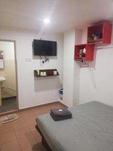 a bedroom with a bed and a flat screen tv at Evonne Budget Hotel in Tanah Rata