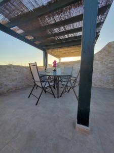 a patio with a table and chairs under a roof at Ático dúplex con piscina privada y vistas al mar en Paraíso de Vera! in Vera