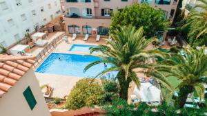 an aerial view of a hotel with a pool and palm trees at Apartamentos Royal Life in Mahón
