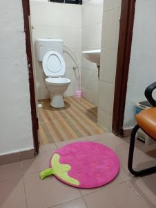 alfombra rosa en el suelo de un baño con aseo en Evonne Budget Hotel, en Tanah Rata