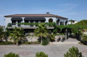 a house with palm trees in front of it at Alacatı Port Ladera Hotel - Adult Only in Alaçatı
