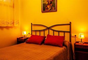 a bedroom with a bed with two red pillows at Apartamento con jardin en un chale in Bueu