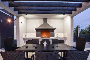 a patio with a table and a fireplace at Villa Gabriel - Dicmo in Dicmo
