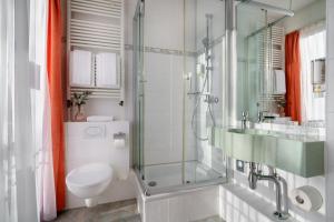 a bathroom with a toilet and a glass shower at Novum Hotel Hagemann Hamburg Hafen in Hamburg