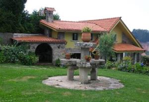 a house with a fountain in front of a yard at Casa Nueva de Bueu in Bueu