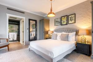 a bedroom with a large white bed and a chair at Alacatı Port Ladera Hotel - Adult Only in Alaçatı