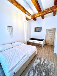 a white bedroom with a bed and a tv at Angel Apartment Černý důl in Černý Dŭl