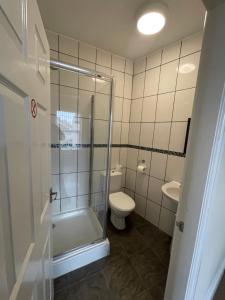 a bathroom with a shower and a toilet and a sink at Mersey view Hotel & Pub in Hale +20 photos