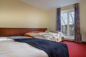 a row of beds in a room with a window at Novum Hotel Hagemann Hamburg Hafen in Hamburg