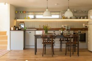 uma cozinha com mesa e cadeiras num quarto em Skylarks, enjoy the decking overlooking your garden and wildflower meadow em Old Newton