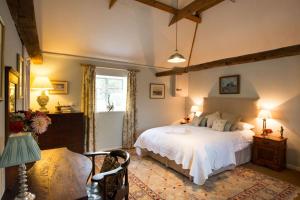 1 dormitorio con cama blanca y ventana en The Stables, relax in 5 star style and comfort with lovely walks all around, en Great Maplestead