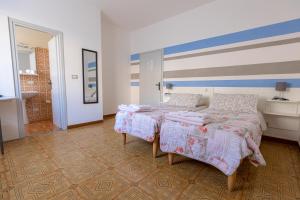 a bedroom with a bed and a blue and white striped wall at La Svolta in Chiuro