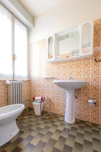 a bathroom with a sink and a toilet and a mirror at La Svolta in Chiuro