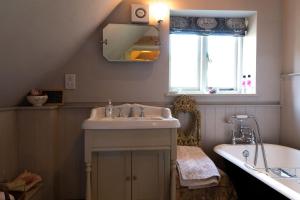 a bathroom with a sink and a tub and a window at Queenies, an authentic Rural Style coastal cottage in a Nature Reserve 