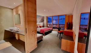 a hotel room with a bed and a sink and a bathroom at Hotel Ortles B&B in Trafoi