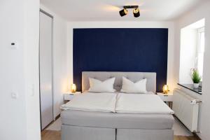 a bedroom with a large bed with a blue wall at Ferienhaus Traumblick direkt am See in Weißenstadt