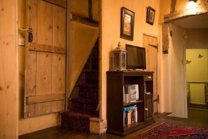 a room with a staircase with a microwave and a tv at The Old Monkey, a quirky bolthole on the edge of a historic Market Town in Hadleigh