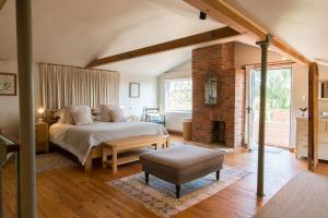 a bedroom with a large bed and a fireplace at The Old Steam Mill, luxury, spacious, beautiful grounds, stunning location in Hartest