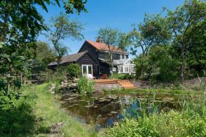 a house with a pond in front of it at Navigation Cottage on the Historic Sea Lock overlooking the Nature Reserve in Maldon