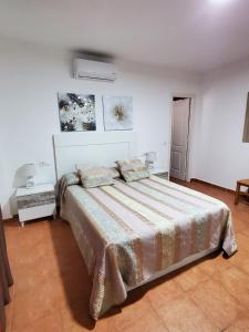 a bedroom with a large bed in a white room at DUPLEX ESPECTACULAR en PRIMERA LÍNEA NATURISTA! in Las Bombardas