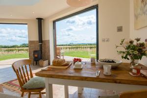 a dining room with a table and a large window at The Hexagon, wow what a location, views over the Essex marshes and sea in West Mersea