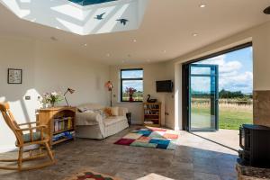 a living room with a ceiling with a skylight at The Hexagon, wow what a location, views over the Essex marshes and sea in West Mersea