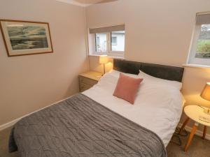 a bedroom with a bed with white sheets and a red pillow at Dinefwr Cottage in Carmarthen
